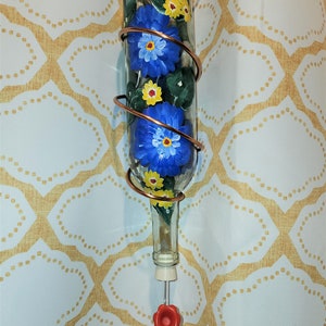 Beautiful hand painted copper wire wrapped wine bottle hummingbird feeder with Cobalt Blue and yellow daisy floral design.