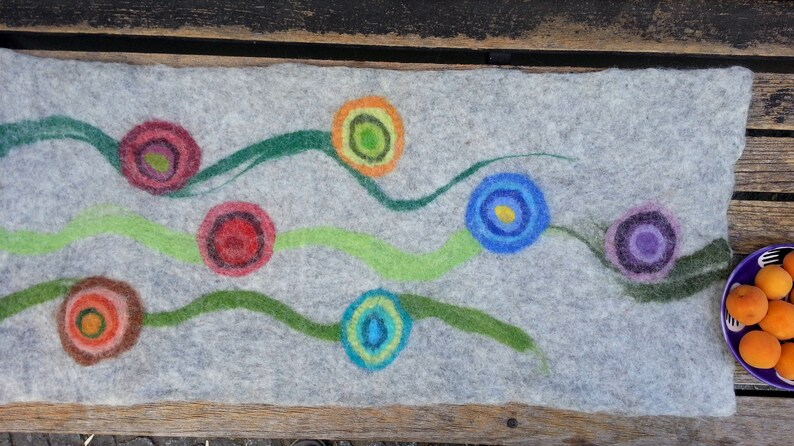 May include: A gray felt runner with colorful circles and green lines. The circles are in shades of red, orange, yellow, blue, and purple.