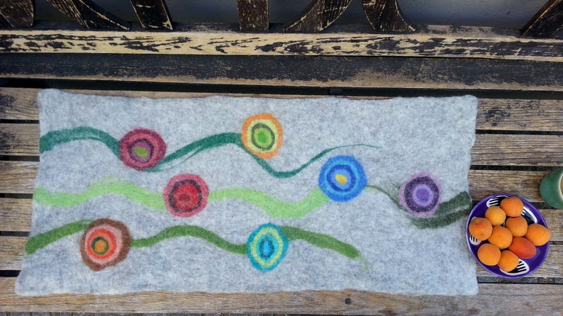 May include: A gray felt pillow with colorful circles and green wavy lines. The circles are in shades of red, blue, green, and purple.