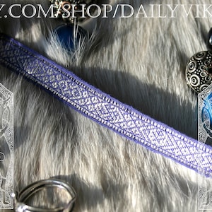 May include: A close-up of a woven purple and silver band with a geometric pattern. The band is displayed on a furry, light gray surface. The Etsy shop name "DAILY VIKING" is visible at the top.