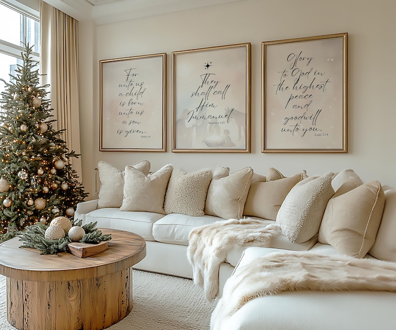 May include: Three framed prints with gold frames and white mats hanging on a beige wall. The prints feature Christmas-themed scripture verses in black calligraphy. The prints are arranged in a row, with the leftmost print featuring the verse "For unto us a child is born, unto us a son is given." The middle print features the verse "They shall call Him Immanuel." The rightmost print features the verse "Glory to God in the highest, and on earth peace, goodwill toward men."