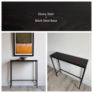 May include: A rectangular console table featuring a dark wood top with an ebony stain and a slim black steel base. The text Ebony Stain + Black Steel Base is visible at the top of the image. The table has four thin legs and a horizontal support bar.