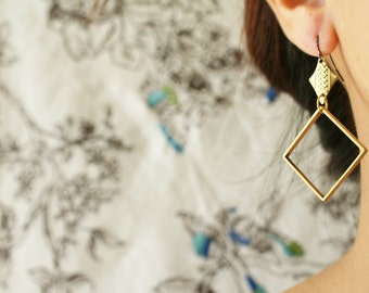 May include: Gold-toned geometric earrings with a square shape and a smaller, textured detail at the top.