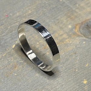 Può includere: Un anello semplice in argento con finitura spazzolata.