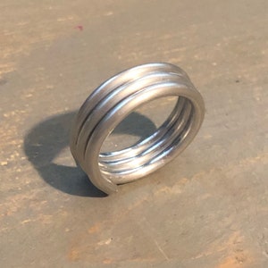 Peut inclure: Une bague en argent composée de plusieurs bandes de métal torsadées.
