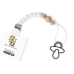Op de afbeelding: Witte en bruine siliconen kralen-speenclip met een girafafbeelding en de tekst "Baby Gigi Boutique Handmade Pacifier Clip".