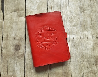May include: Red leather journal with a 20-sided die embossed on the front.