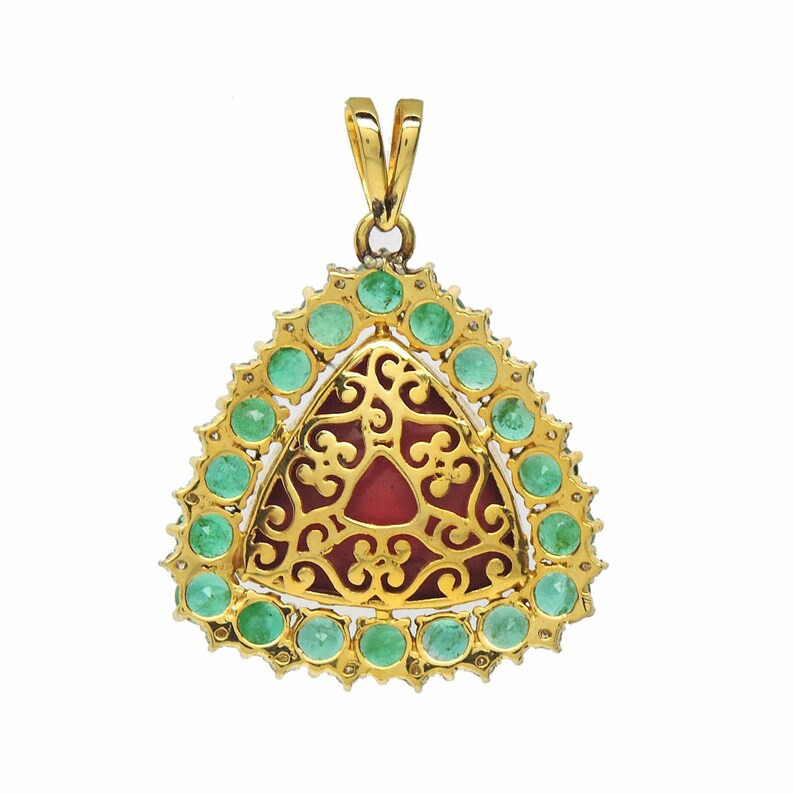 May include: A gold pendant featuring a red stone set within a filigree design, encircled by a border of green gemstones.