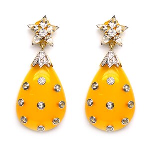 May include: A pair of yellow teardrop-shaped earrings with a star-shaped diamond cluster at the top and smaller diamonds set around the teardrop.