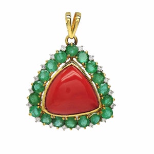 May include: A gold pendant featuring a triangular red coral gemstone surrounded by a halo of green emeralds and white diamonds.