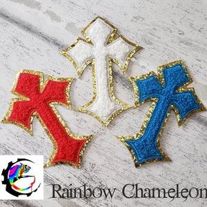 May include: Three felt cross patches with gold glitter trim. The crosses are red, white, and blue.