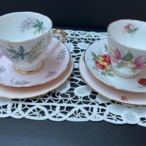 Vintage mismatched china trios, two settings, each with a side plate and a tea cup and saucer