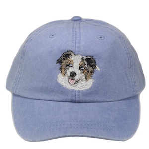 May include: A blue baseball cap with an embroidered image of an Australian Shepherd dog.