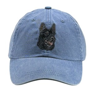 K&ouml;nnte beinhalten: Eine blaue Jeans-Baseballkappe mit einem gestickten schwarzen Kopf eines Deutschen Sch&auml;ferhundes.