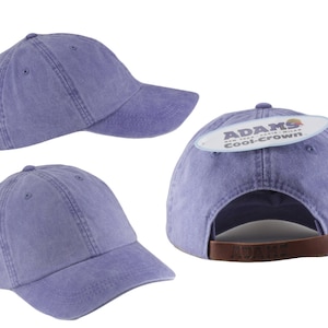 May include: A purple cotton baseball cap with a brown leather strap and a label that reads "ADAMS cool-crown".