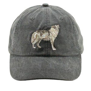 May include: A black baseball cap with an embroidered image of a wolf howling at the moon. The wolf is gray and brown with a white chest.