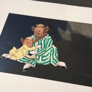 May include: A cartoon illustration of two cows in green and white striped pajamas. The larger cow is sitting with a book in its lap, while the smaller cow is leaning against the larger cow. The background is a dark blue.