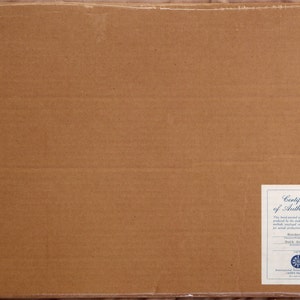May include: A brown cardboard box with a white certificate of authenticity sticker. The sticker has the text "Certificate of Authenticity" and "This hand-signed animation of one produced by the studio using the same materials and techniques as the original production." It also includes the text "Roadster's "Back Seat" 2004" and a logo for the International Animated Film Society.