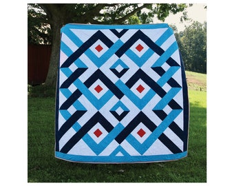 May include: A quilt pattern called "Pathfinder" by Alison Barry Quilting. The quilt is 80 inches by 80 inches and features a geometric design in blue, white, black, and red. The quilt is displayed outdoors on a grassy lawn.