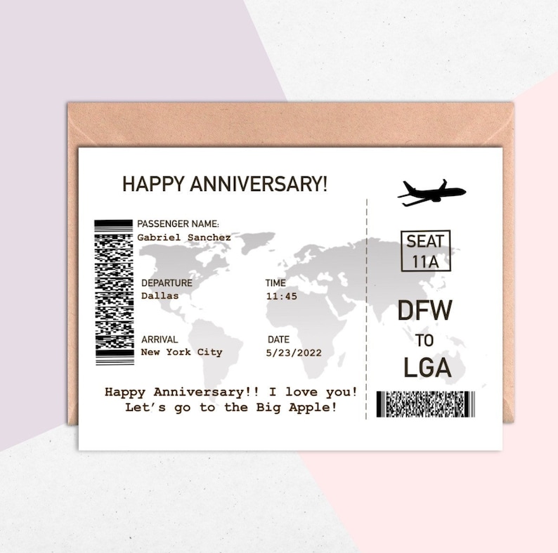 May include: A white card with a black and white airplane ticket design. The card says "Happy Anniversary!" and "Let's go to the Big Apple!" The ticket is for a flight from Dallas to New York City on May 23, 2022. The passenger name is Gabriel Sanchez.