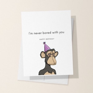May include: A birthday card with a cartoon monkey wearing a pink and blue party hat. The card says "I'm never bored with you" and "Happy Birthday".