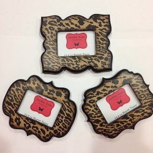 May include: Three magnet frames with a leopard print design. Each frame has a black border and a white insert with the text "Familiar Faces" and "2.5 x 3.5 Magnet Frame". The frames are in various shapes.