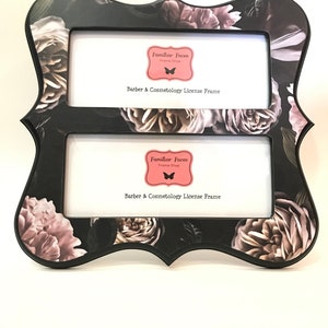 May include: A black double license frame with a floral rose pattern in grey and pink. The frame has a decorative shape and includes the text "Familiar Faces Frame Shop" and "Barber & Cosmetology License Frame".