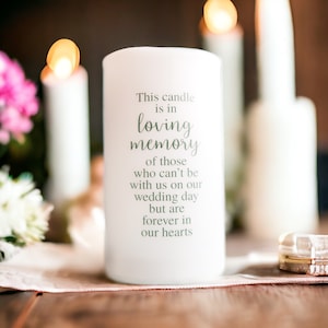 May include: White pillar candle with the text "This candle is in loving memory of those who can't be with us on our wedding day but are forever in our hearts".