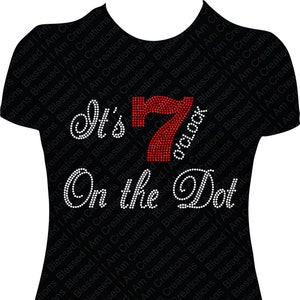 Puede incluir: Una camiseta negra con brillantes blancos que deletrean "It's 7 o'clock on the dot" con un número 7 de brillantes rojos.