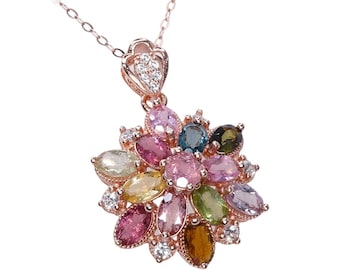 May include: A rose gold necklace featuring a pendant with a floral design. The pendant is adorned with a cluster of colorful, oval-cut gemstones in shades of pink, green, yellow, and blue, accented by small white gemstones.