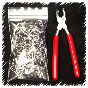 May include: A clear plastic bag filled with silver metal jump rings and a pair of red handled pliers with silver metal jaws.