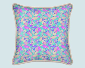 Cojín de seda [relleno]: Estampado abstracto de hojas en tonos turquesa y rosa, ribete trenzado.