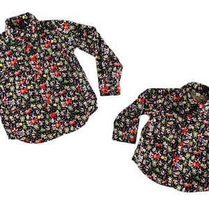 May include: Two long-sleeved shirts with a black background and a Christmas-themed print featuring Santa Claus, reindeer, and other holiday icons.