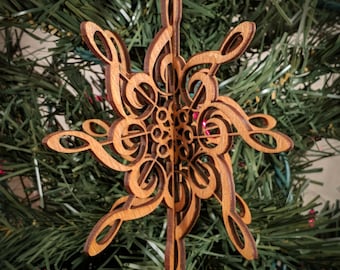 May include: A wooden Christmas ornament shaped like a snowflake with intricate details. The ornament is made of laser-cut wood and features a design of musical notes.