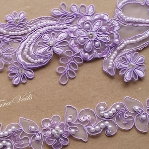May include: Lilac floral lace trim with pearl and rhinestone embellishments. The trim is shown in two different designs, both with a delicate, feminine look.