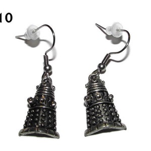 May include: A pair of silver earrings featuring a detailed Dalek design. The earrings are on a silver hook.