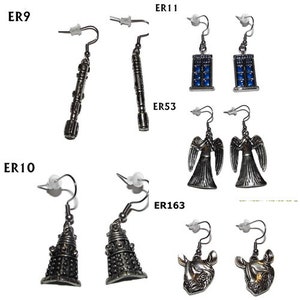 Op de afbeelding: Een set van 10 paar zilverkleurige oorbellen met verschillende Doctor Who-themaontwerpen, waaronder de TARDIS, Daleks en Weeping Angels. De oorbellen zijn gelabeld met hun bijbehorende productcodes: ER9, ER10, ER11, ER53 en ER163.