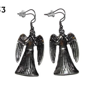 May include: A pair of silver angel earrings with a detailed design. The angels have wings and are in a praying position.