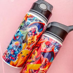May include: Two water bottles with black lids and vibrant cartoon character designs. The bottles have a white base and are decorated with characters in shades of blue, red, yellow, and green. The bottles are likely made of metal or plastic.