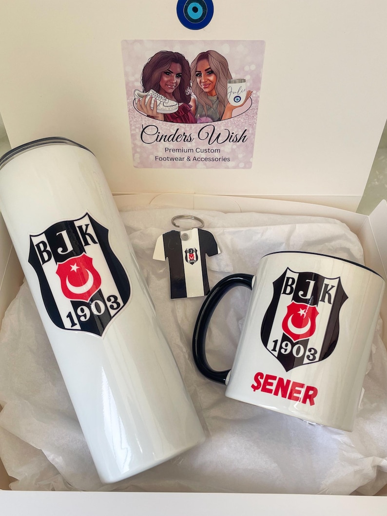 May include: A white gift box with a white mug, a white tumbler, and a keychain with a black and white jersey. The mug and tumbler have a black and white logo with the text "BJK 1903" and the mug also has the text "SENER".