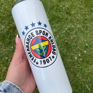 May include: White stainless steel tumbler with a blue, yellow, and red logo that says "Fenerbah&ccedil;e Spor Kul&uuml;b&uuml; 1907" with five blue stars above the logo.