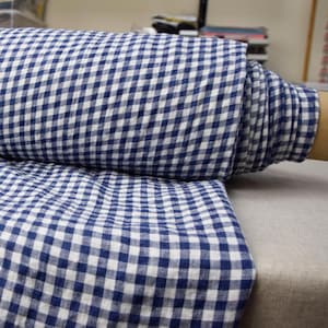 May include: A roll of white and blue gingham fabric. The fabric has a checkered pattern with small squares.