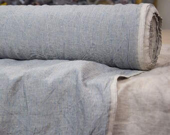 May include: A roll of blue and white striped linen fabric. The fabric has a textured, slightly wrinkled appearance.
