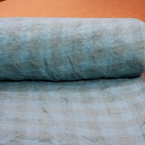 K&ouml;nnte beinhalten: Eine Rolle blauen Leinenstoffs mit einem dezenten Karomuster. Der Stoff ist weich, strukturiert und perfekt f&uuml;r eine Vielzahl von N&auml;hprojekten.