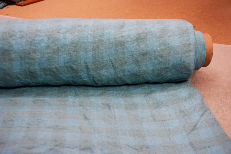 K&ouml;nnte beinhalten: Eine Rolle blauen Leinenstoffs mit einem dezenten Karomuster. Der Stoff ist weich, strukturiert und perfekt f&uuml;r eine Vielzahl von N&auml;hprojekten.