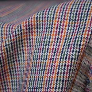 Linen/cotton fabric Mabela Multicolor Tweed. Quite heavy weight striped twill. Very small woven houndstooth pattern, color mix: beige, green, orange, burgundy, navy. Aesthetic, strong and durable, organic, antistatic, breathing, pleasant to touch.