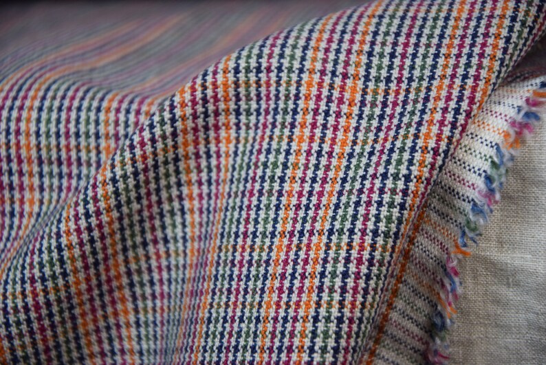 Linen/cotton fabric Mabela Multicolor Tweed. Quite heavy weight striped twill. Very small woven houndstooth pattern, color mix: beige, green, orange, burgundy, navy. Aesthetic, strong and durable, organic, antistatic, breathing, pleasant to touch.