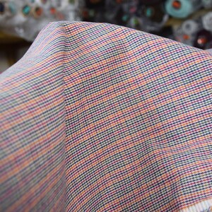Linen/cotton fabric Mabela Multicolor Tweed. Quite heavy weight striped twill. Very small woven houndstooth pattern, color mix: beige, green, orange, burgundy, navy. Aesthetic, strong and durable, organic, antistatic, breathing, pleasant to touch.