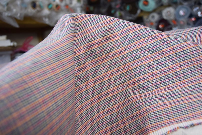Linen/cotton fabric Mabela Multicolor Tweed. Quite heavy weight striped twill. Very small woven houndstooth pattern, color mix: beige, green, orange, burgundy, navy. Aesthetic, strong and durable, organic, antistatic, breathing, pleasant to touch.