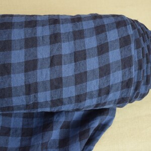 K&ouml;nnte beinhalten: Eine Rolle blauer und schwarzer Gingham-Stoff. Der Stoff hat ein kariertes Muster und ist aus Leinen.